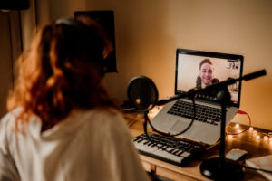 Male singing student having an online lesson with a redheaded singing teacher with a title individual coaching.
