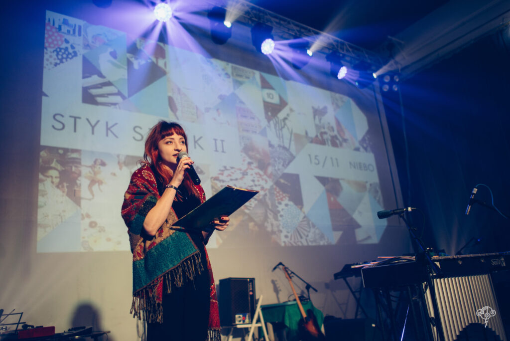 Redheaded woman Aleksandra hosting an art event called Styk Sztuk in Niebo, club and concert venue in Warsaw, Poland.